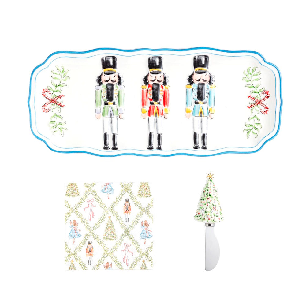 Holiday hostess set featuring a nutcracker tray, matching printed napkins, and a Christmas tree spreader.