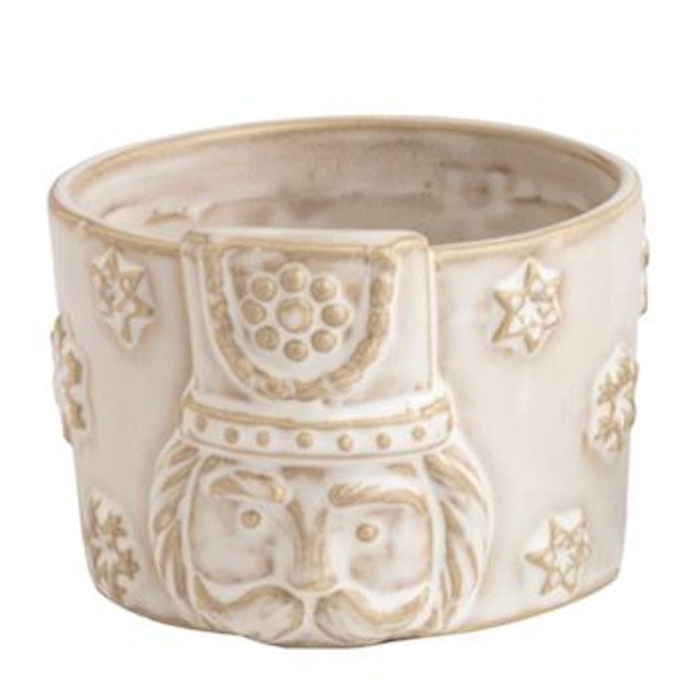Off-white ceramic nutcracker tidbit dish with gold accents and embossed stars.