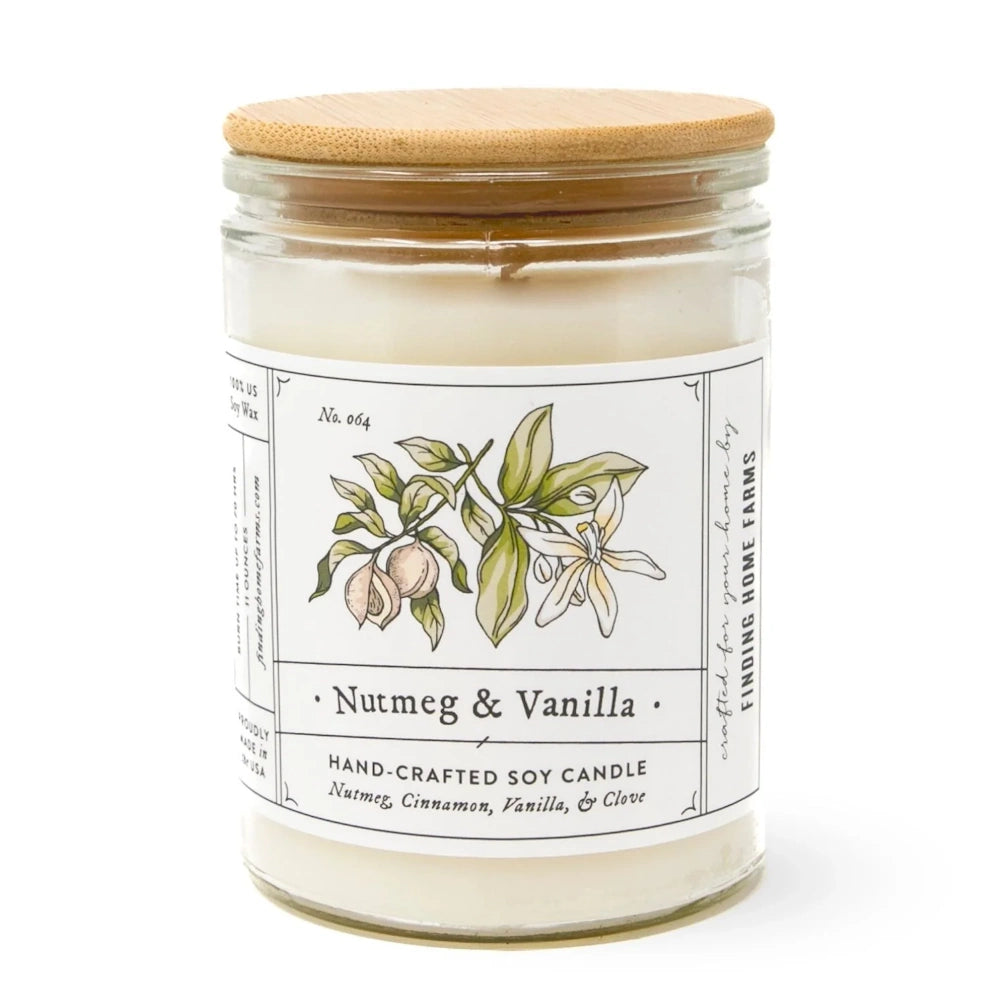 A glass jar soy candle with a wooden lid and a label reading Nutmeg & Vanilla Hand-Crafted Soy Candle.