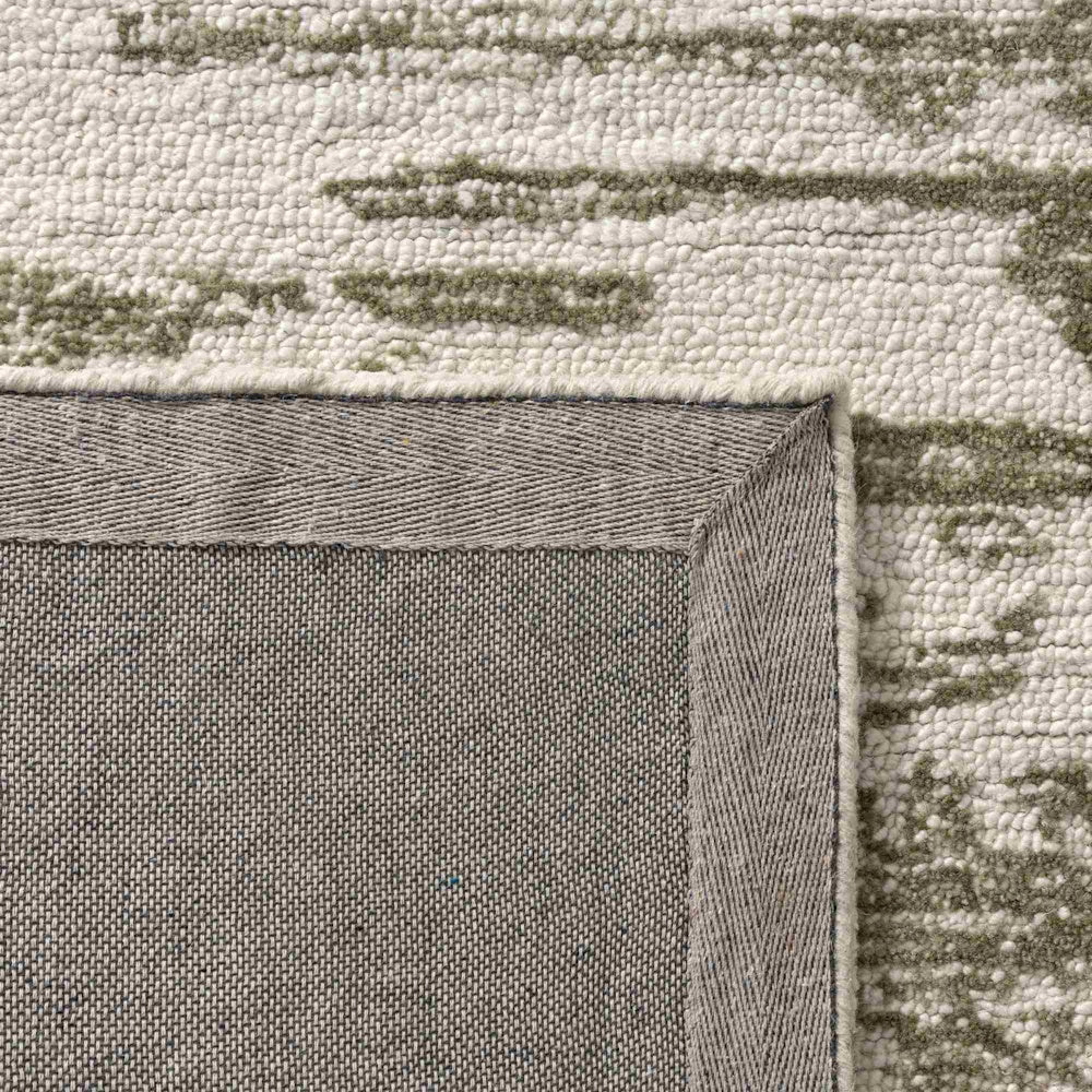 Detail of the Nuvia hand-tufted rug back and green ivory loop pile texture with durable reinforced canvas backing.