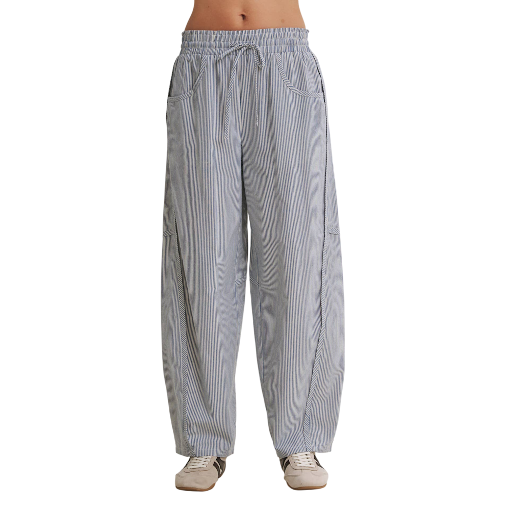 Front view of blue and white pinstriped drawstring barrel pants featuring side pockets and sneakers.