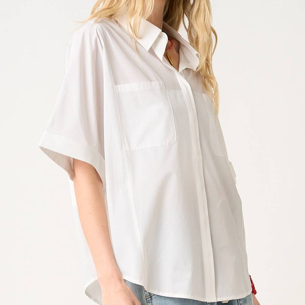 Off-white short-sleeve button-down shirt with a soft stretch woven fabric, dual chest pockets, and a relaxed fit.