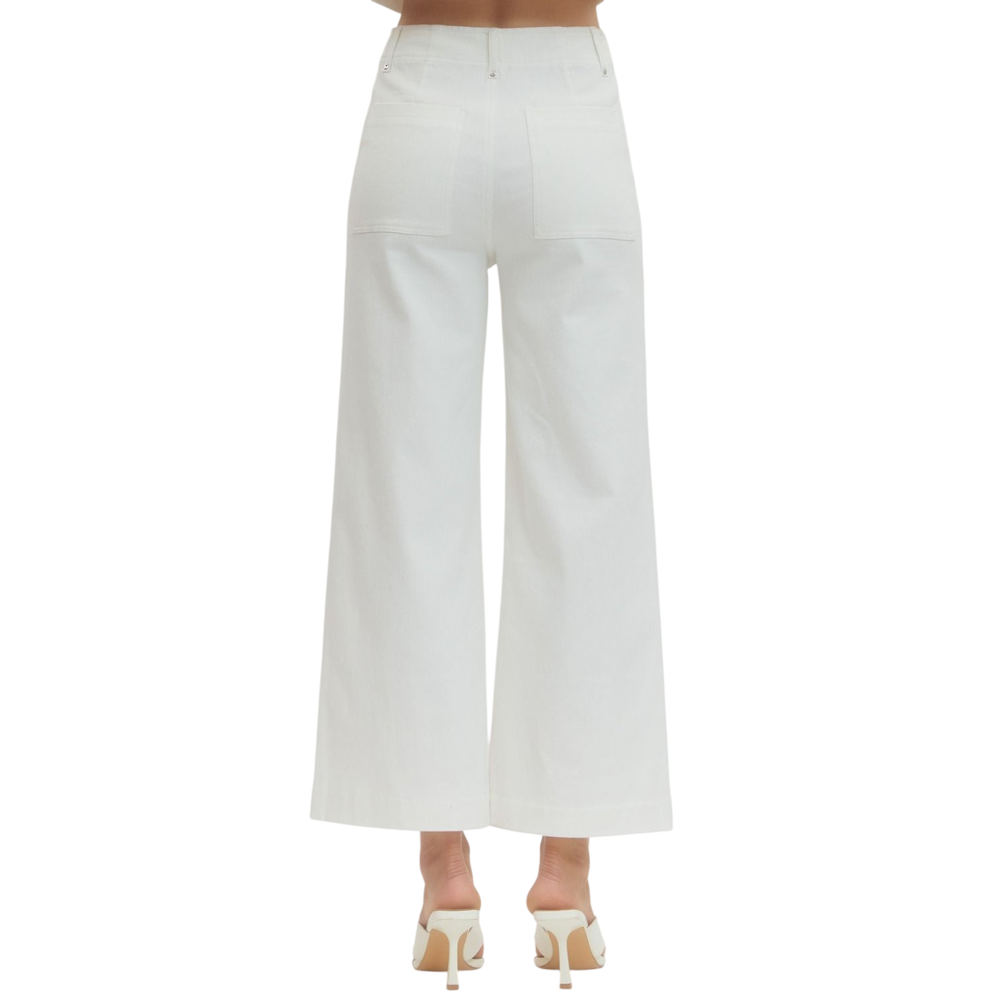 Back view of a person wearing off-white, high-waisted, wide-leg pants with two large back pockets.