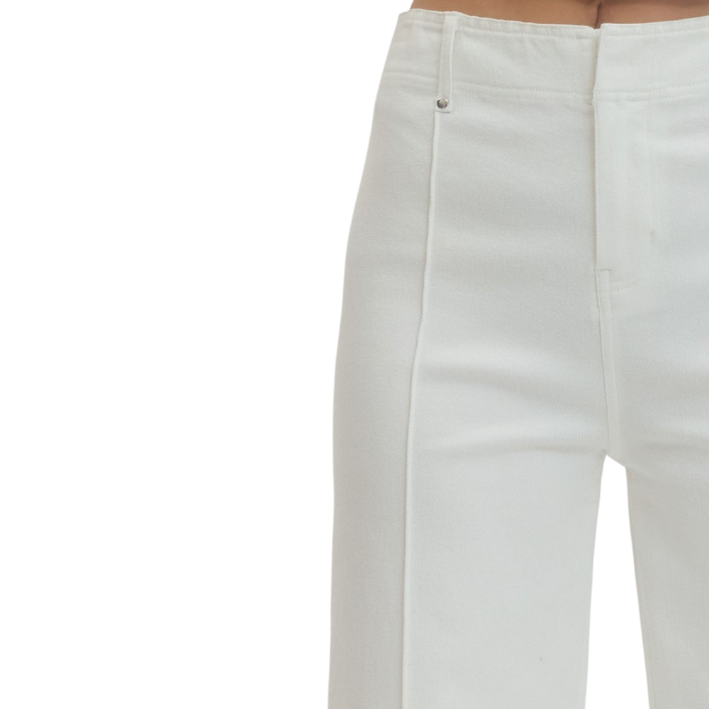 Close-up of a person wearing off-white, high-waisted pants with a distinct front seam detail.