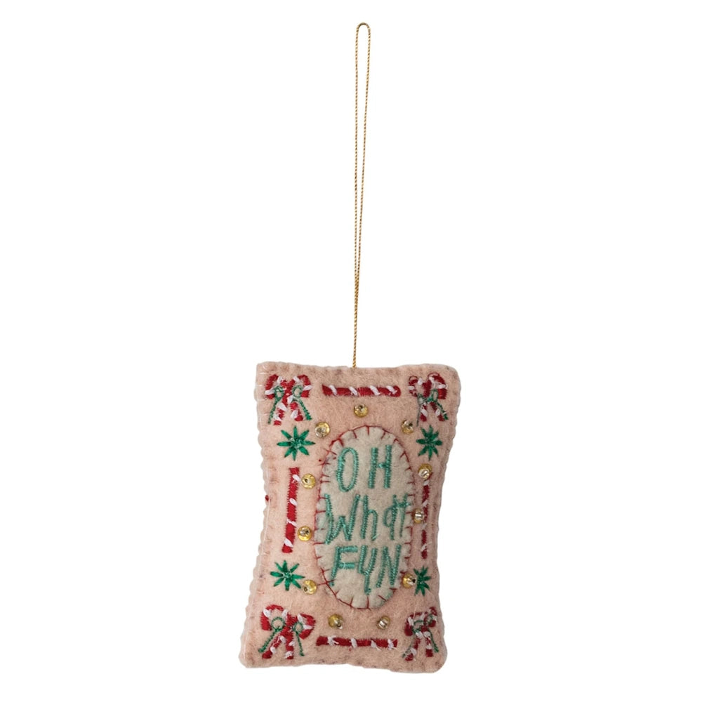 Front view of a pink wool felt holiday ornament featuring embroidered green Oh What Fun text.