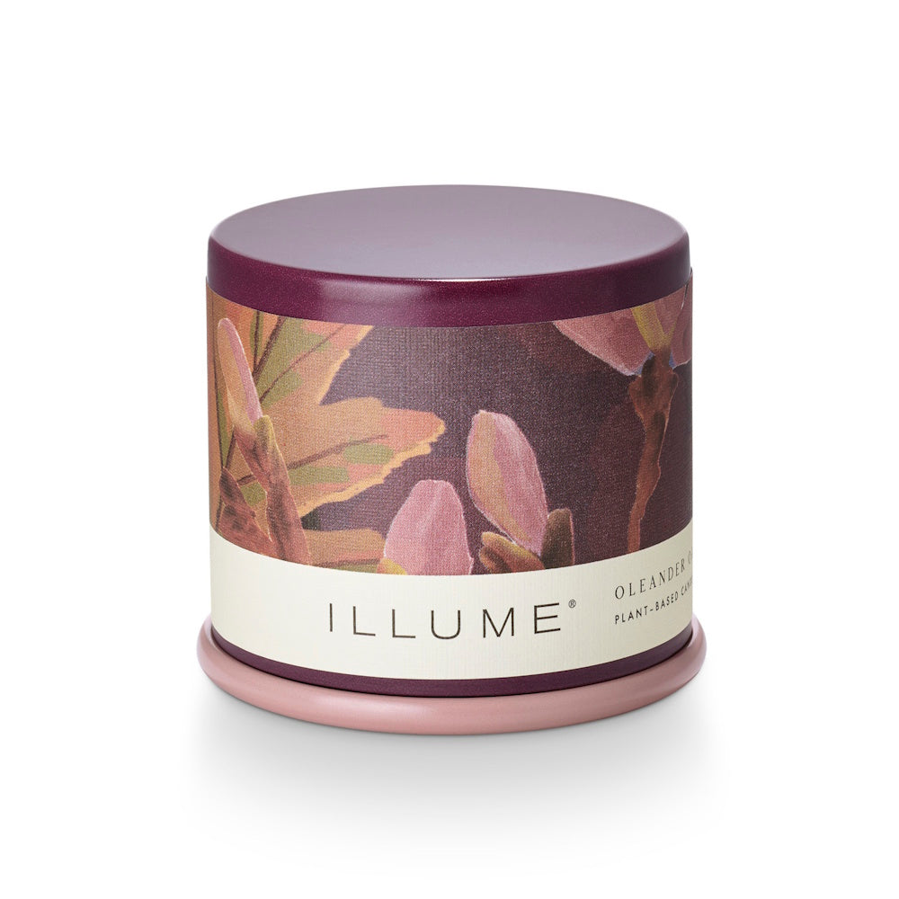 Illume Oleander & Oak plant-based tin candle featuring a floral design and plum lid.