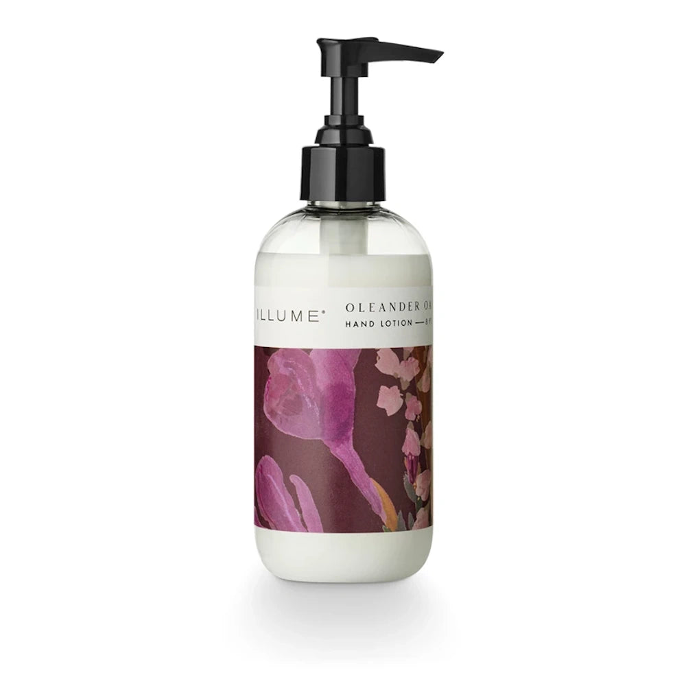 Illume Oleander Oak hand lotion in a clear pump bottle with a floral purple and burgundy label on a white background.