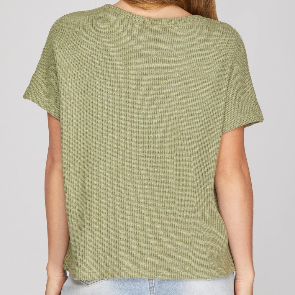 Back view of an olive green knit top with a round neck and relaxed drop shoulder short sleeves.