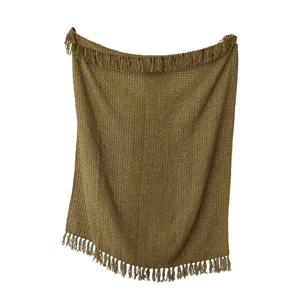 Olive green waffle-weave throw blanket with fringed edges hanging vertically against a white background.