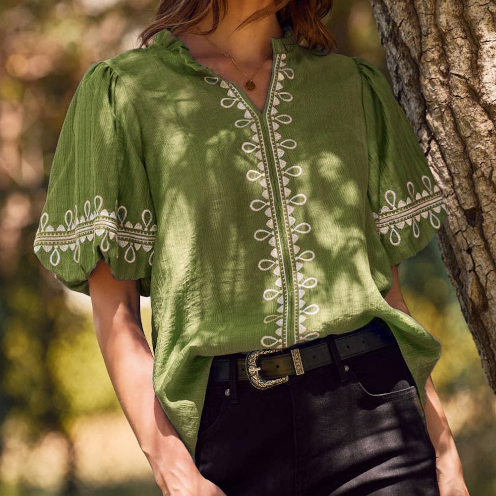 Olive green split-neck blouse featuring white embroidery along the front placket and short bubble sleeves.