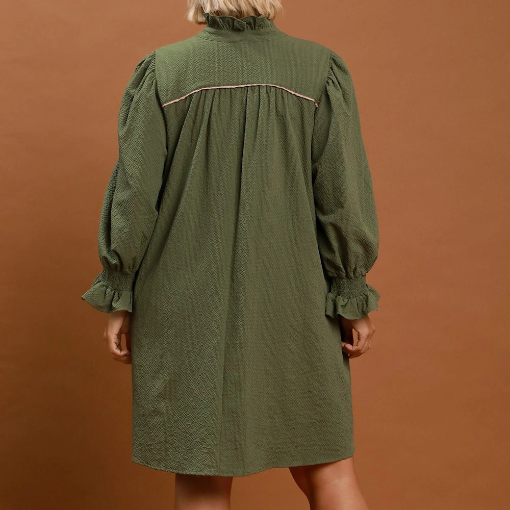 Back view of an olive green textured mini dress featuring long puff sleeves and ruffled cuffs.