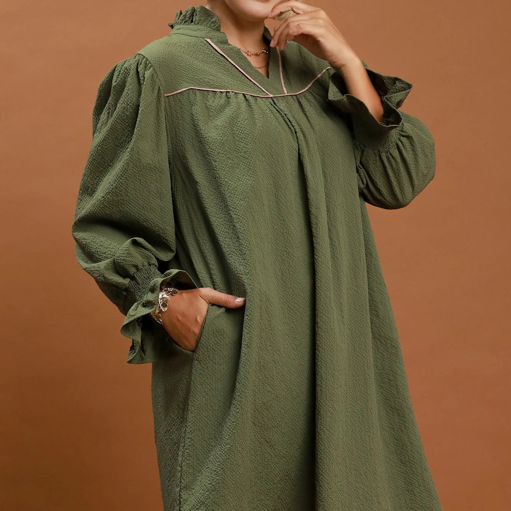 Olive green textured mini dress with long puff sleeves, ruffled cuffs, pink trim, and side pockets.