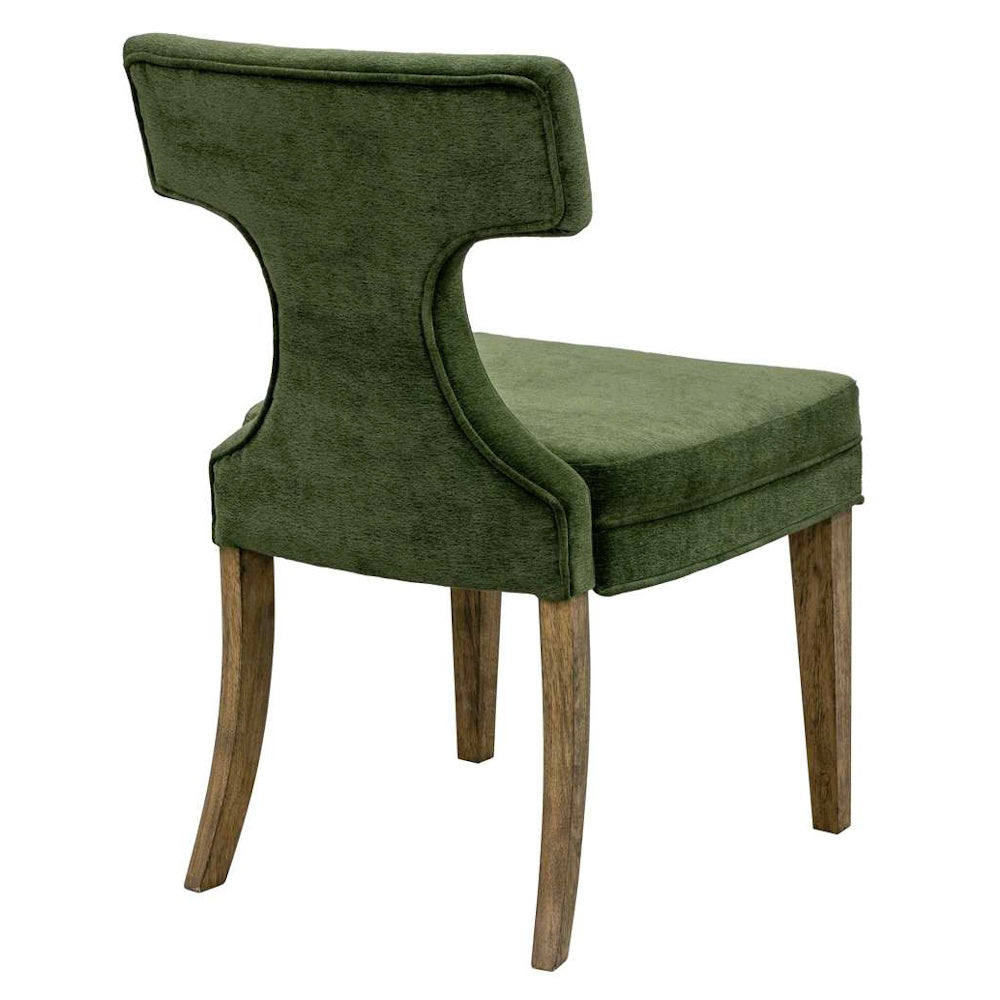 Back view of an upholstered olive green velvet dining chair featuring curved, weathered wood legs.