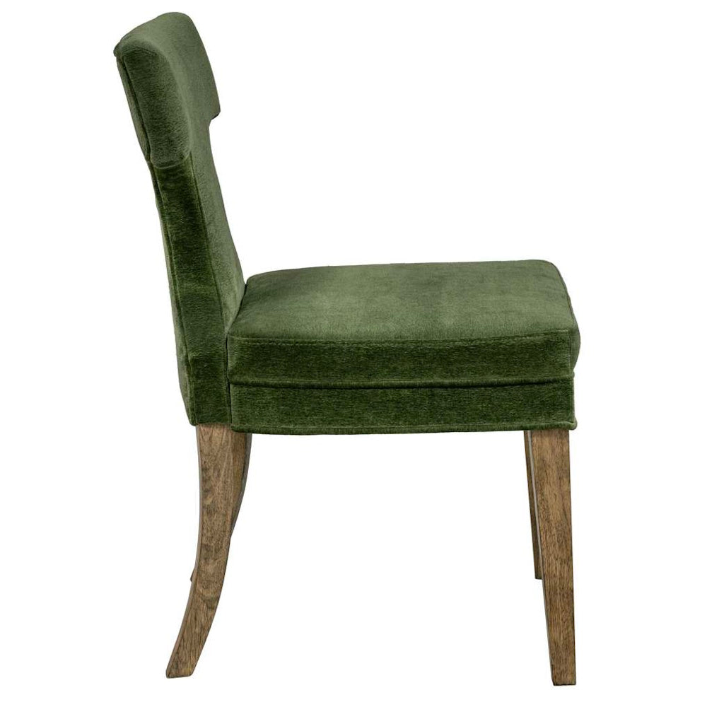 Side view of a moss green velvet upholstered dining chair with rustic wooden legs.