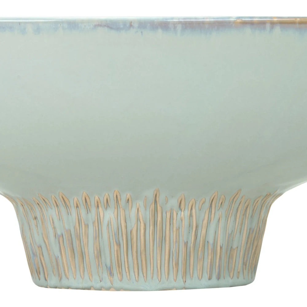 Close-up of a light blue ceramic bowl with a textured, vertically grooved base.