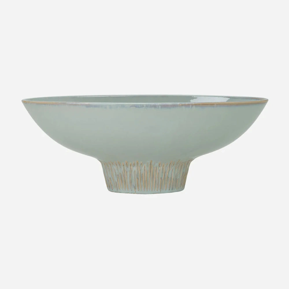 A light sage green ceramic footed bowl with a textured, ribbed pedestal base and brown rim accent.