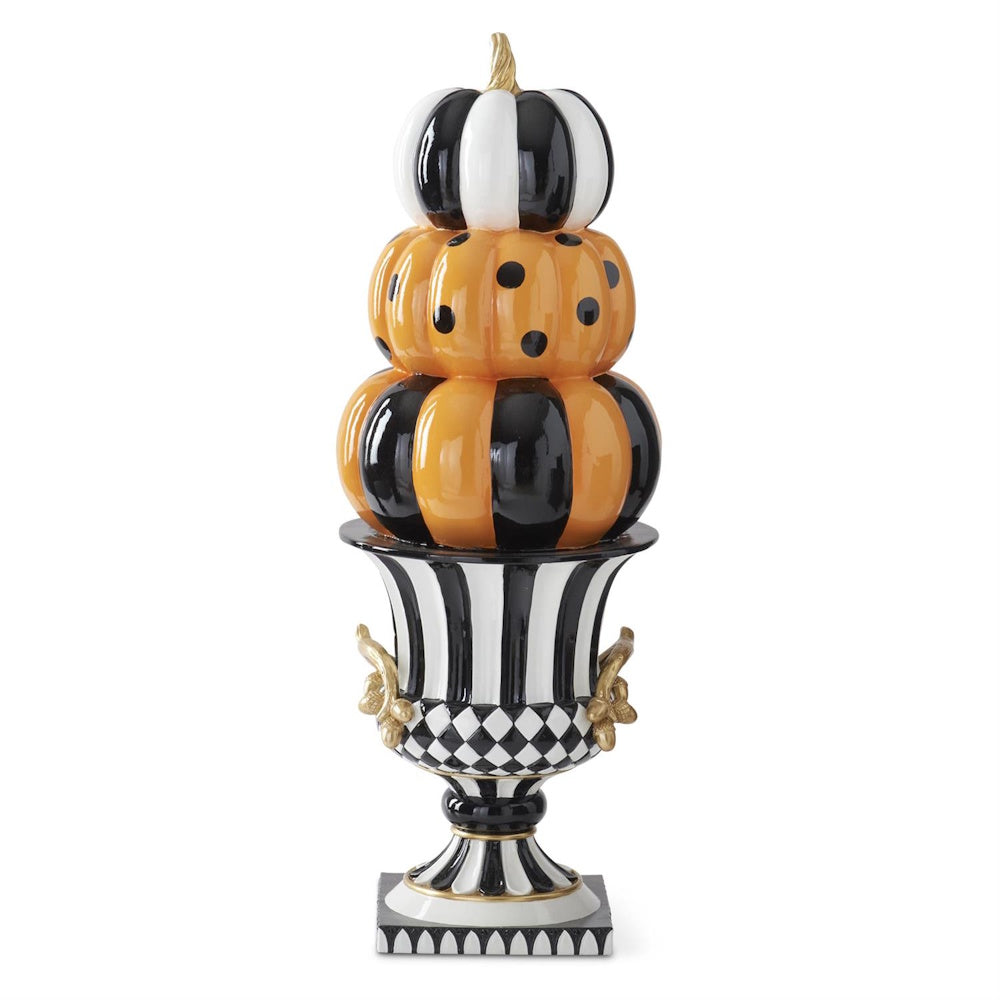 Stacked patterned pumpkins in black, white, and orange set atop a decorative pedestal urn.
