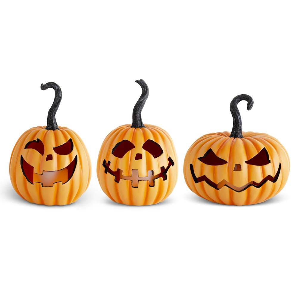 Three orange resin LED jack-o'-lanterns with black curly stems and spooky carved faces on a white background.