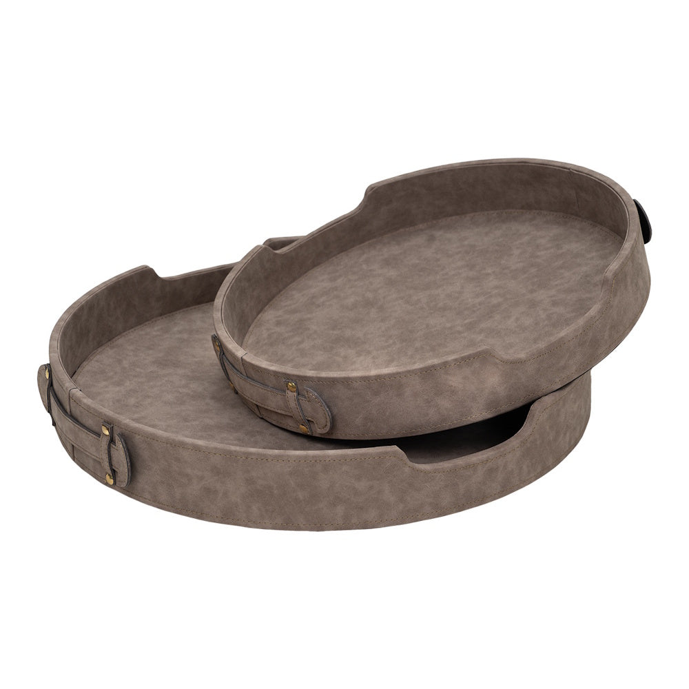 Two round, grey faux-leather nesting trays with stitched handles and brass studs, stacked on a white background.