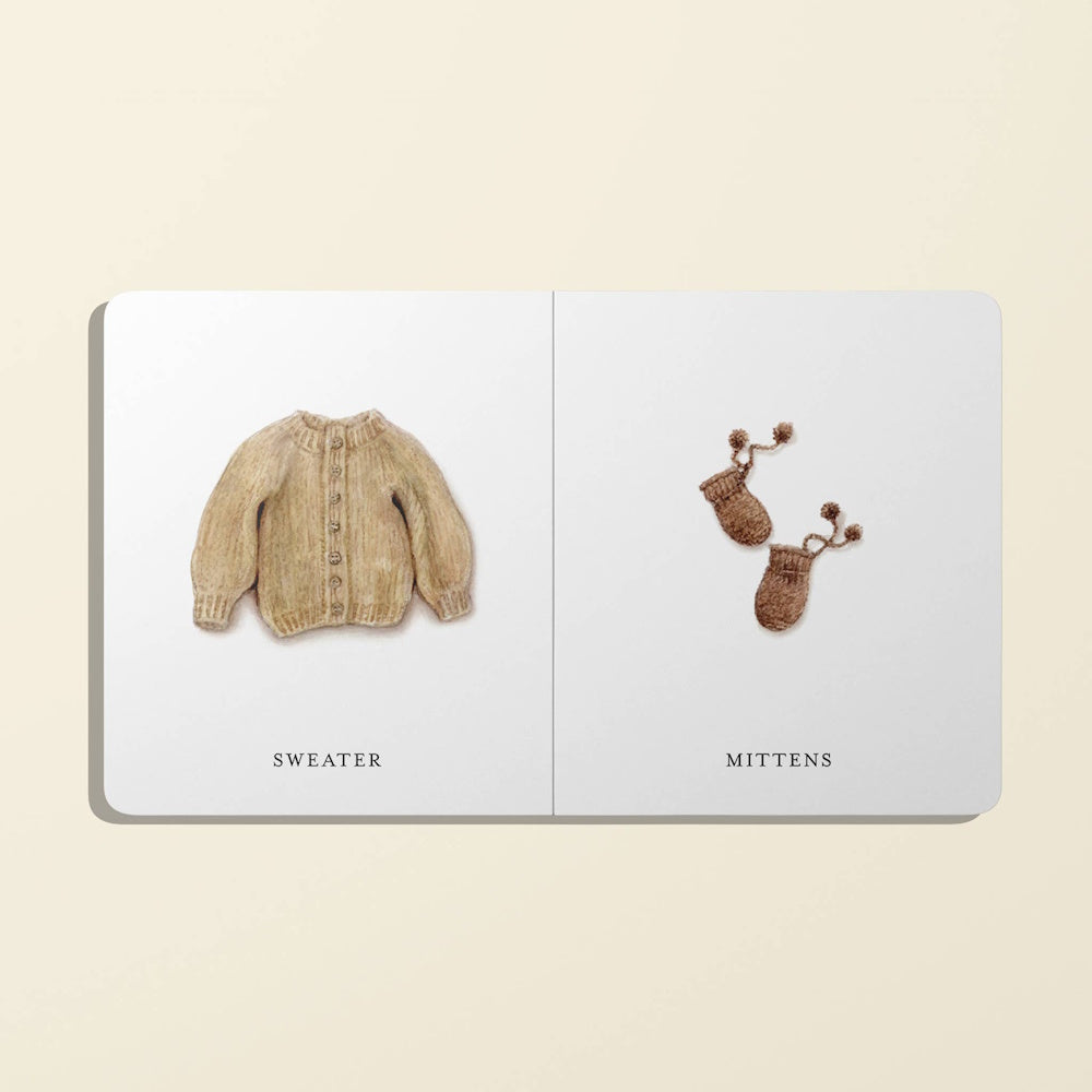 Illustrations of a tan knit cardigan sweater and matching brown knit mittens on a white board book spread.