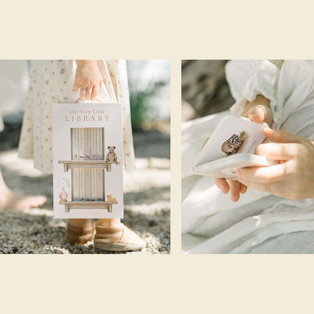 Child holding Our Very Little Library board book set and flipping through a small board book with a raccoon illustration.