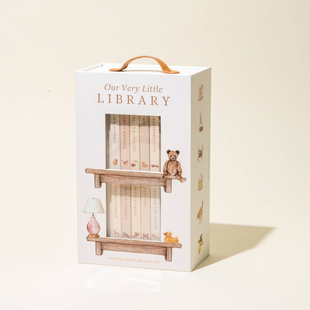 Our Very Little Library board book set by Tabitha Paige in a white carrying case with a leather handle and animal illustrations.