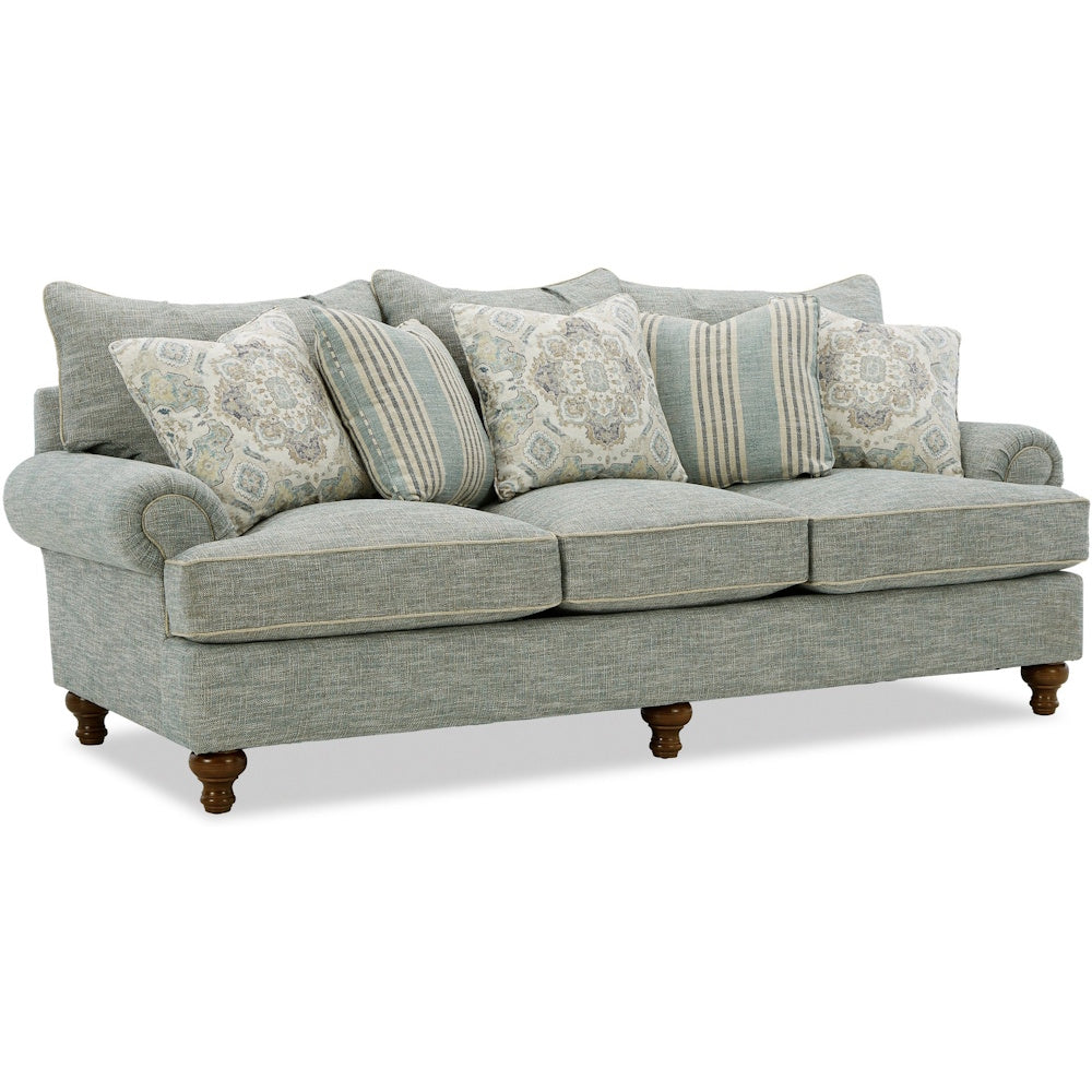 Light blue three-cushion sofa with rolled arms, wooden legs, and patterned accent pillows.