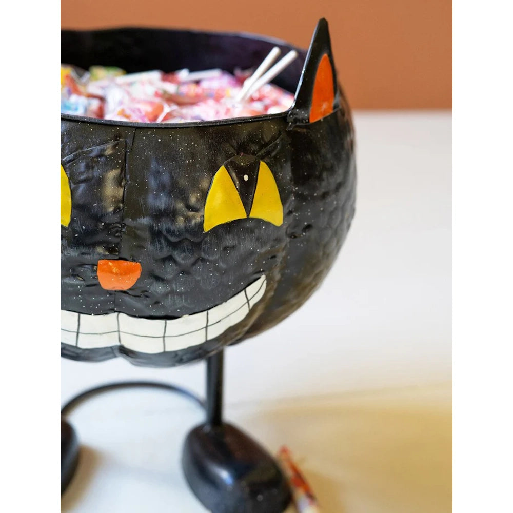 Halloween black cat candy bowl made of painted metal and filled with treats.