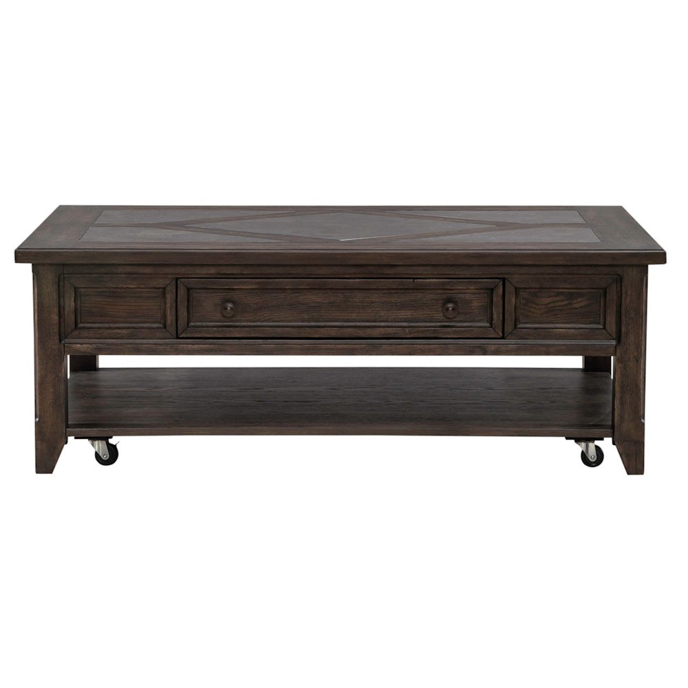 Front view of rustic dark wood coffee table with center drawer, lower shelf, caster wheels and paneled top design.