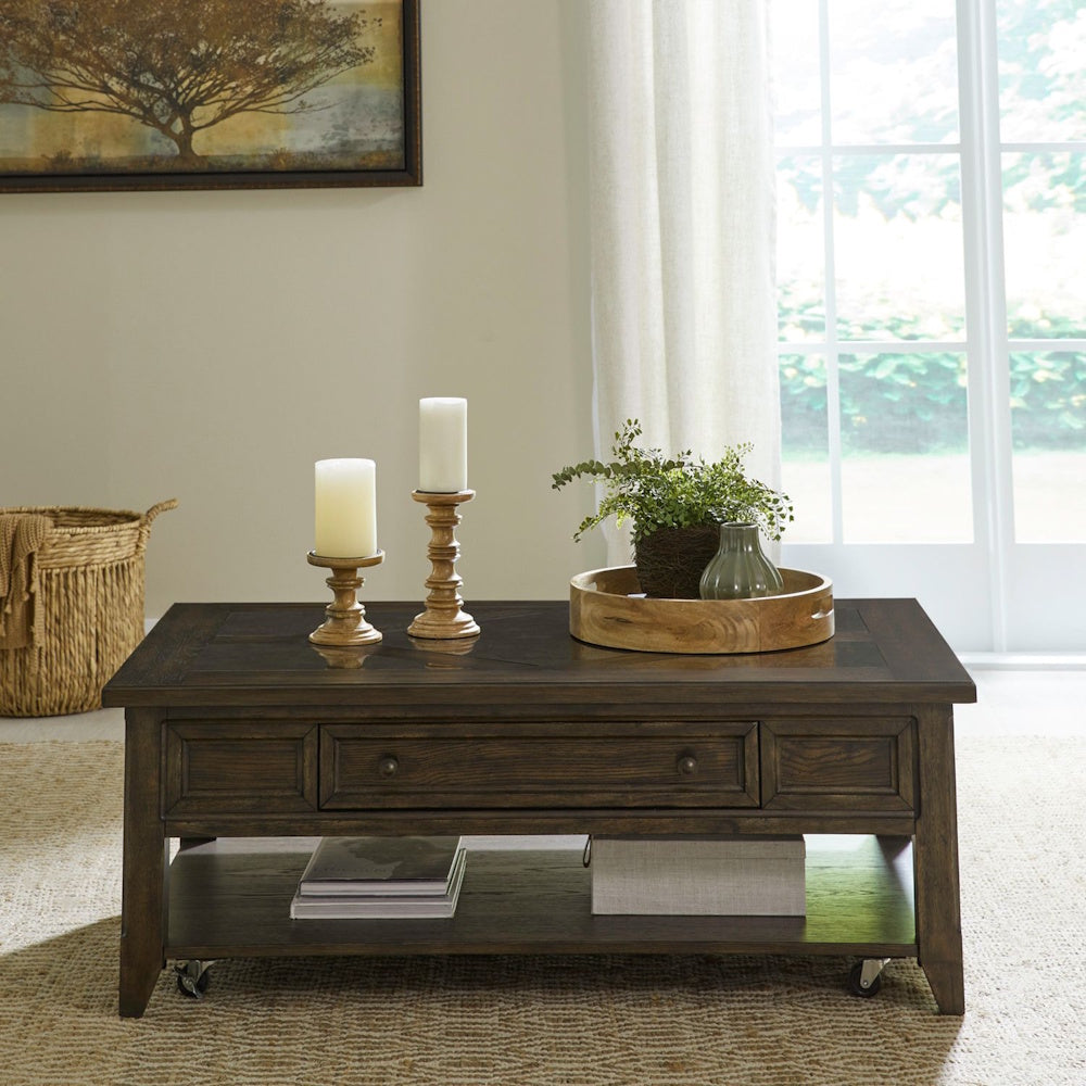 Rustic dark wood coffee table styled in a living room with drawer storage, open shelf and decorative accents.