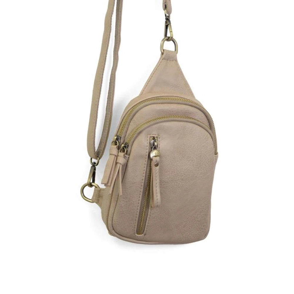 Parchment-colored Skyler sling bag with multiple zippered pockets and an adjustable crossbody strap on a white background.