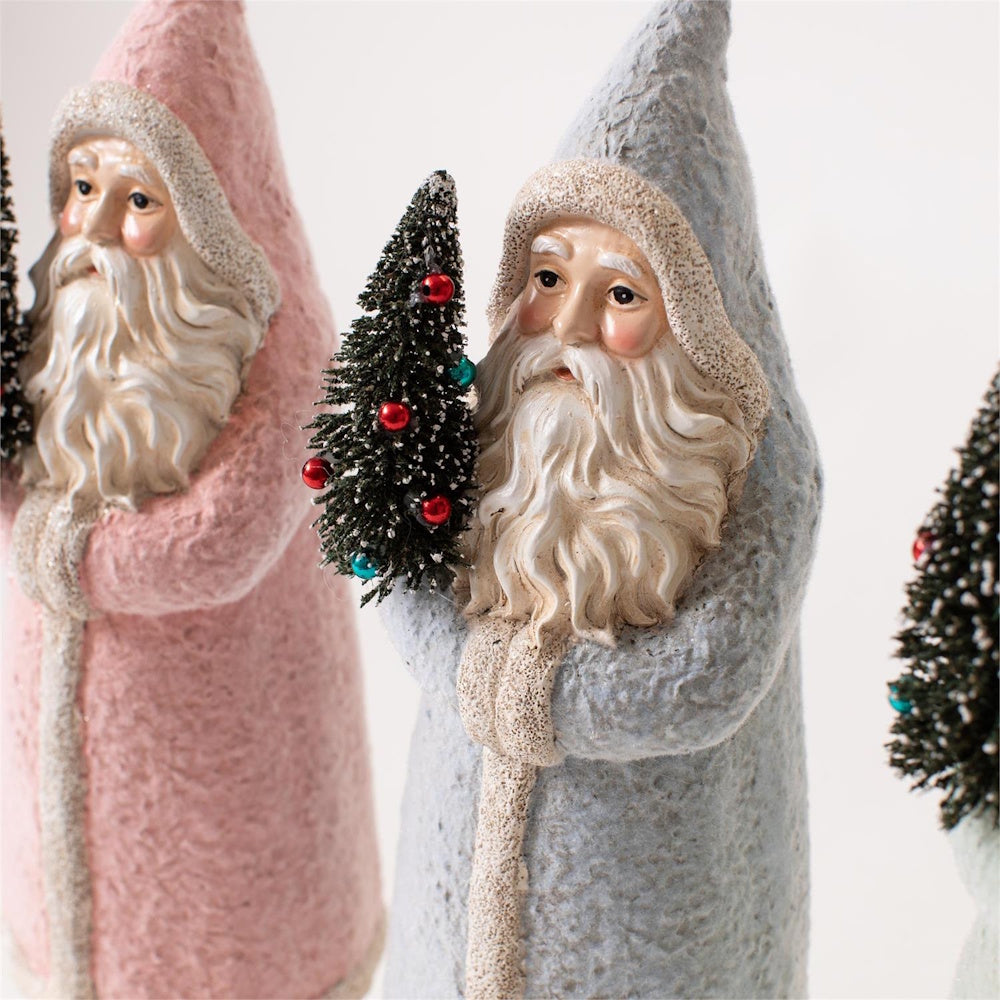 Pastel blue and pink Belsnickel Santa figurines holding mini decorated Christmas trees.