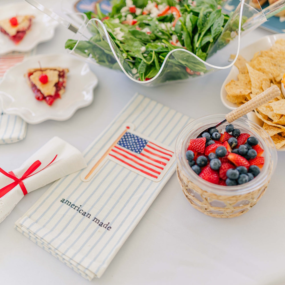 American flag patch hand towel with "american made" text, surrounded by 4th of July party food and fresh berries.
