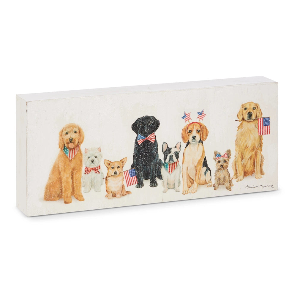 Seven dogs sit in a row, wearing patriotic bow ties and holding small American flags. The scene conveys a festive, celebratory tone.