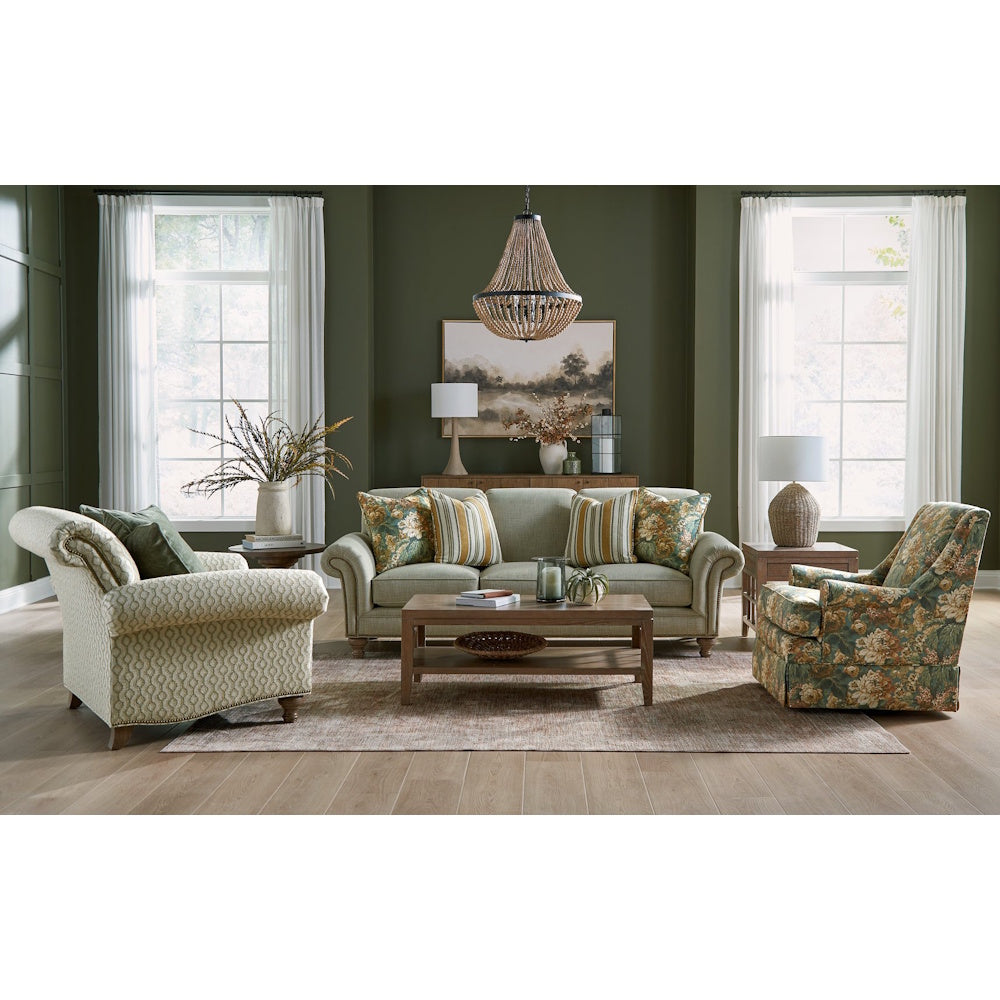 Elegant living room with a light green sofa, patterned accent chairs, wooden coffee table, and dark green walls.