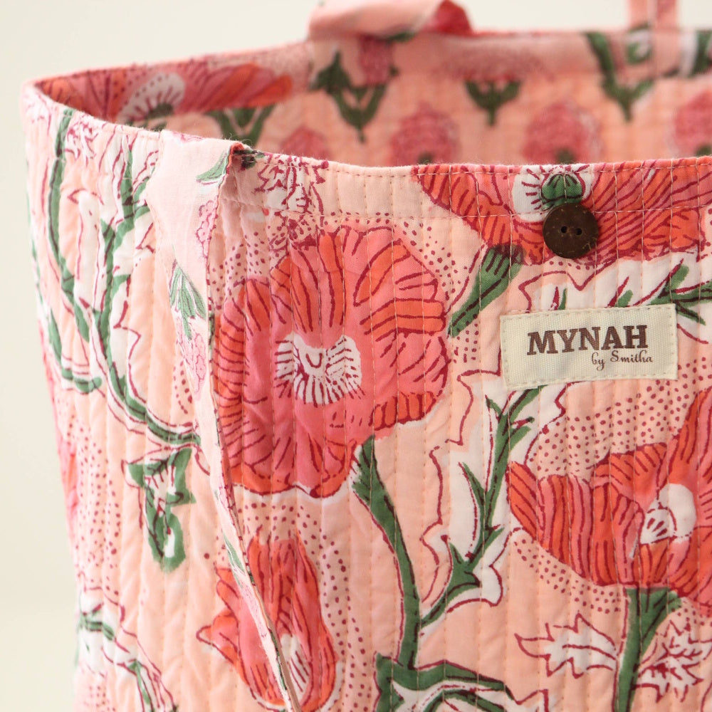 Quilted peach tote bag with orange poppy floral print, wooden button detail, and MYNAH by Smitha brand label.