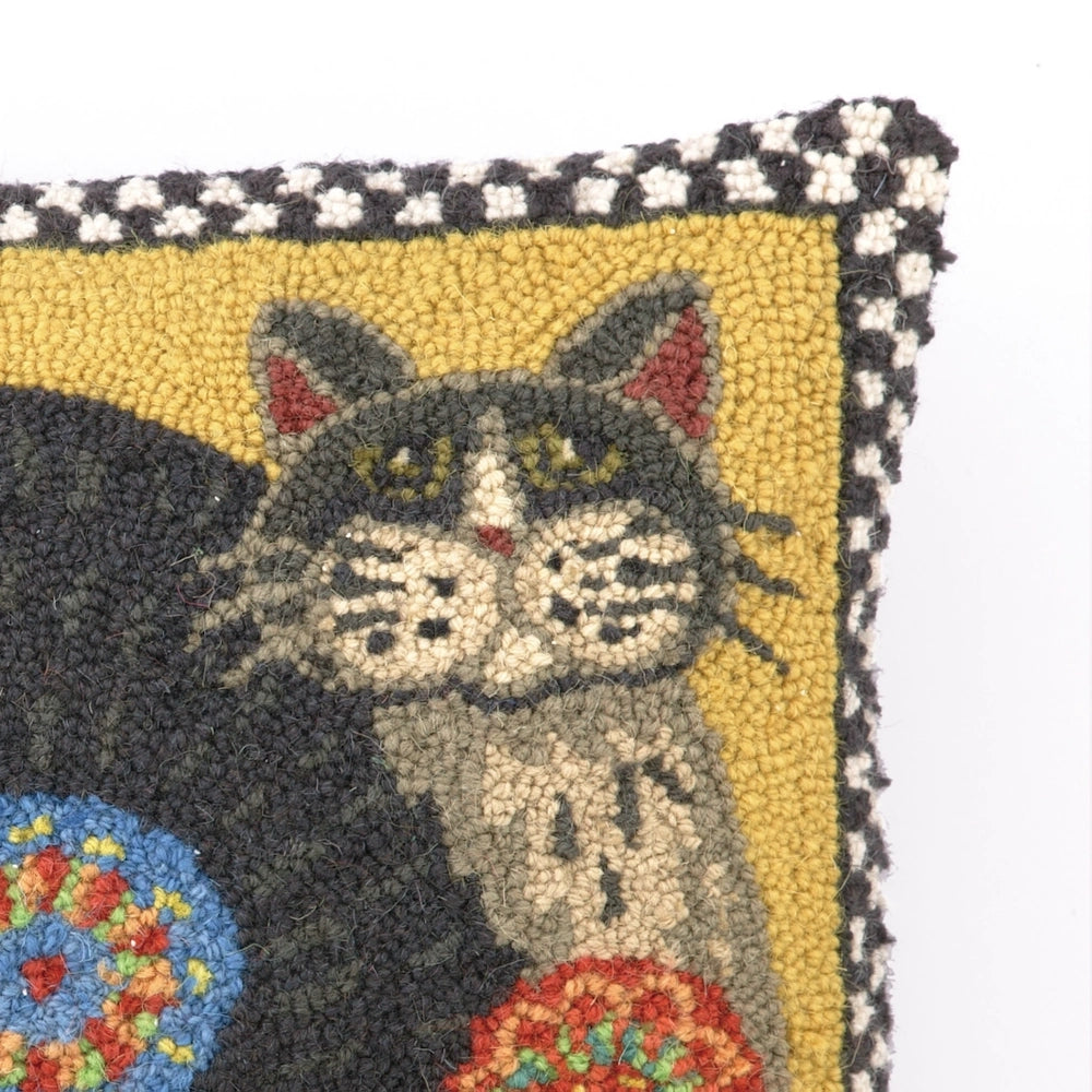 Close-up of a hooked rug pillow showing a detailed view of a grey and black cat's face on yellow.