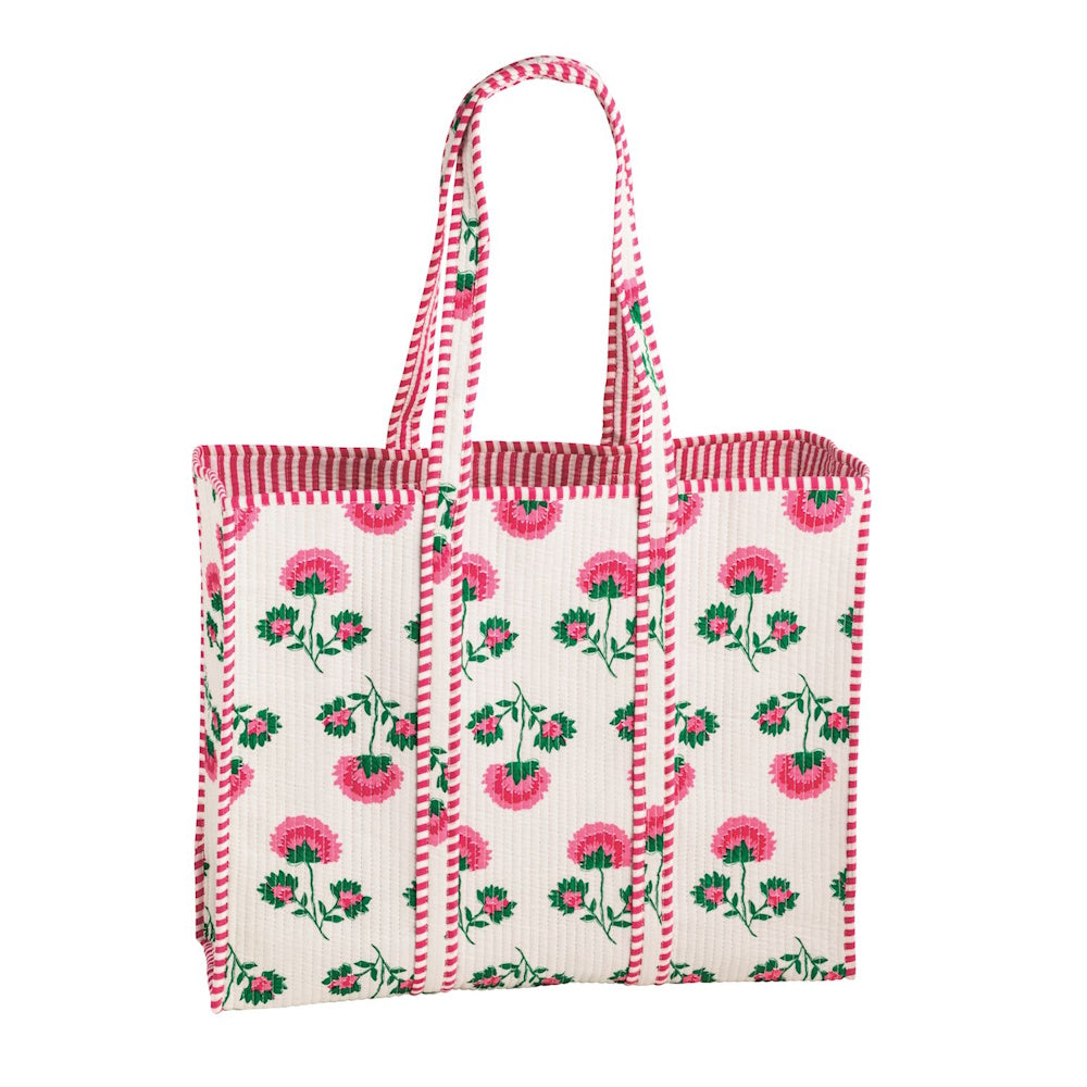 Pink floral block print quilted tote bag with striped handles and trim.