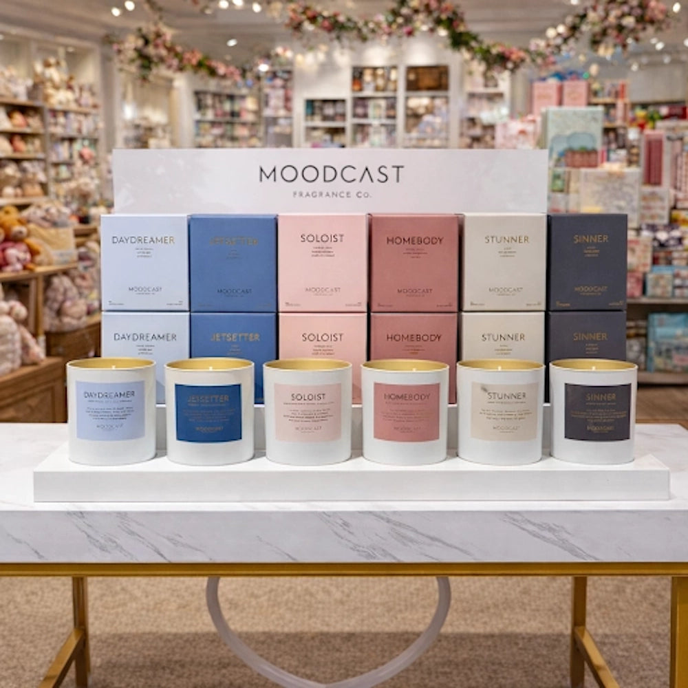 Moodcast Fragrance Co. display featuring boxed candles and lit testers on a retail counter.