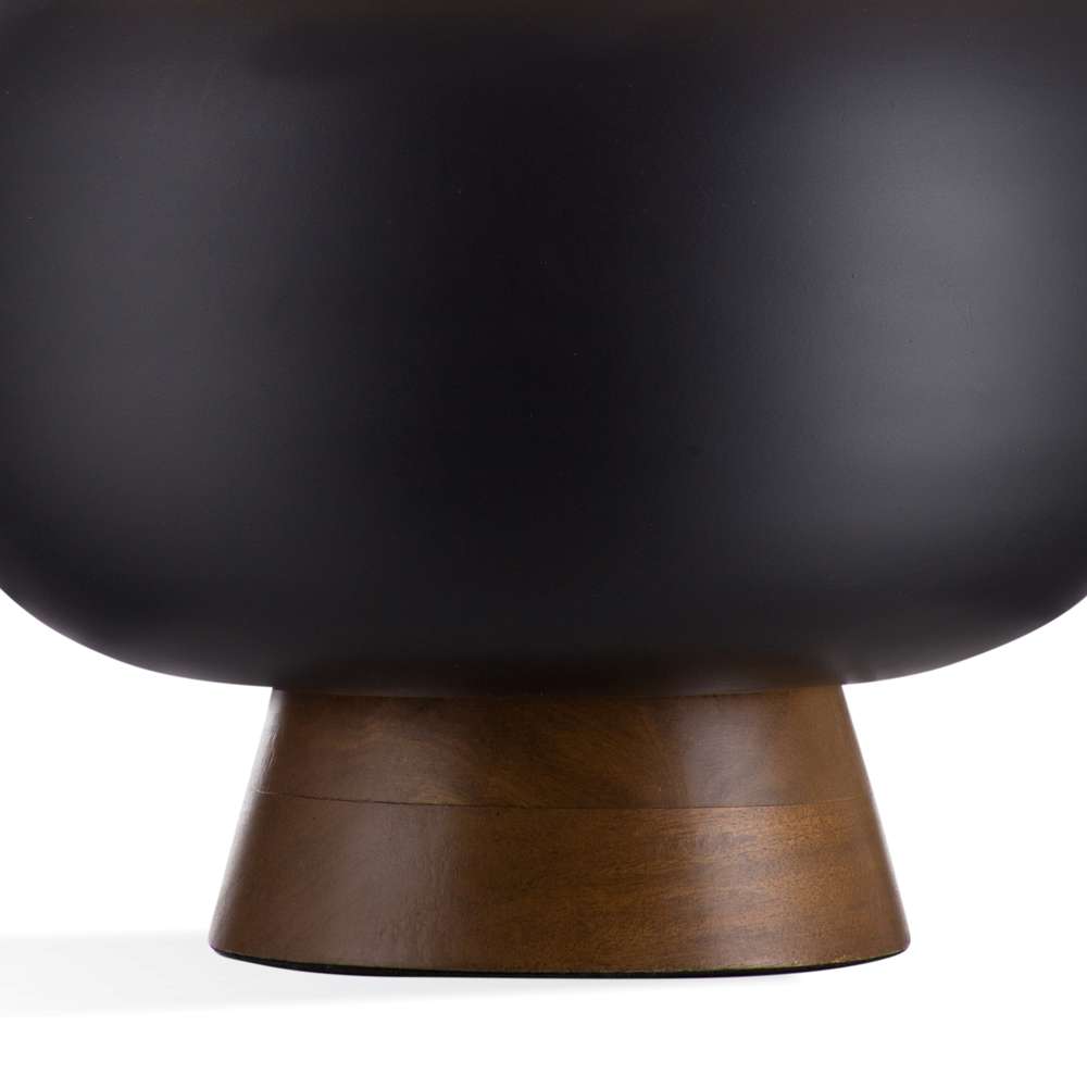 Modern matte black pedestal bowl with a tapered dark wood base for minimalist home decor.