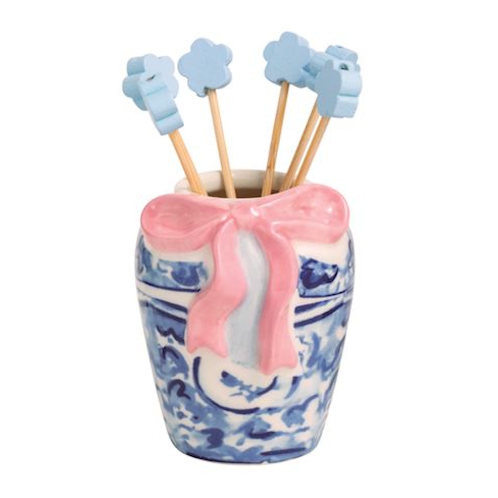 Blue and white chinoiserie toothpick holder with a pink bow and flower-topped picks.