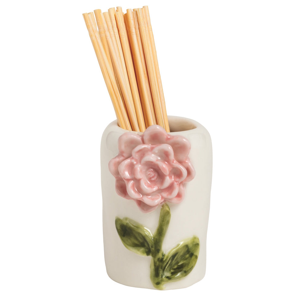 A small, white ceramic toothpick holder featuring a 3D pink rose and green stem, filled with wooden toothpicks.