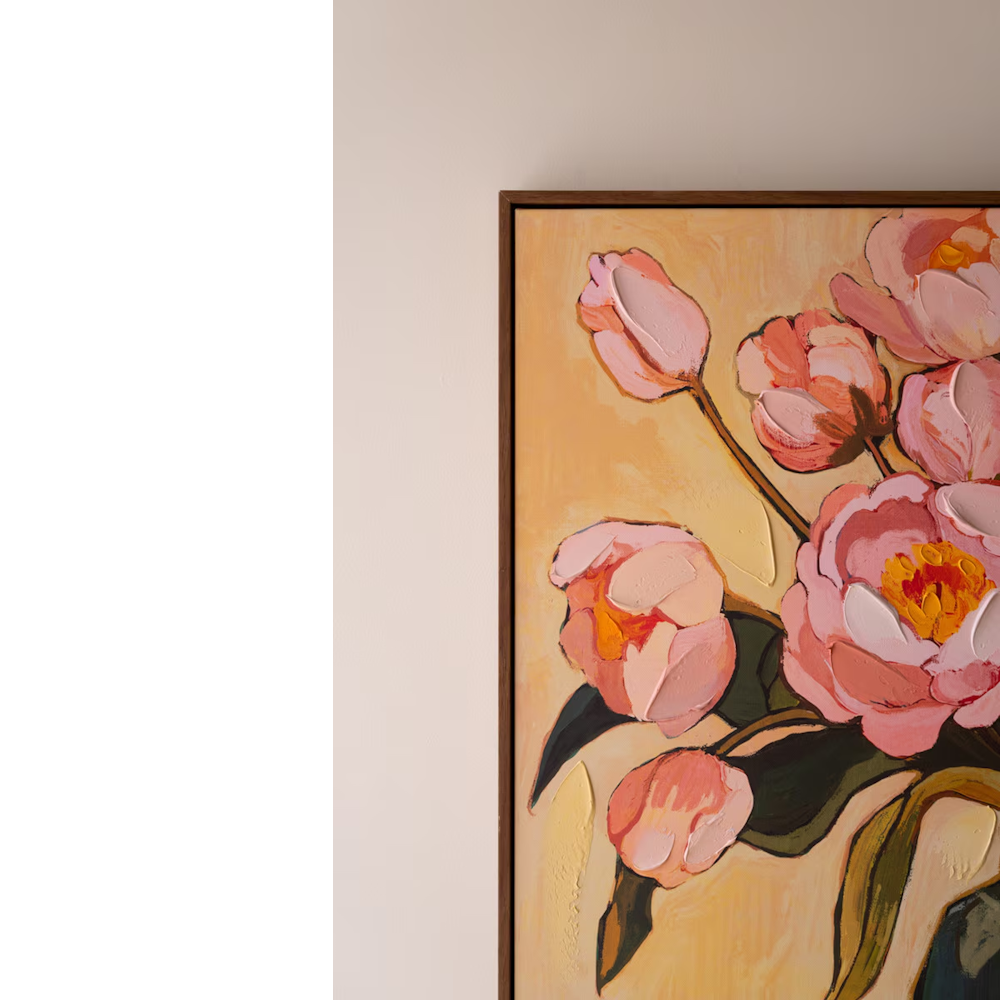 Top corner detail of framed floral wall art with textured pink peonies against a cream wall.