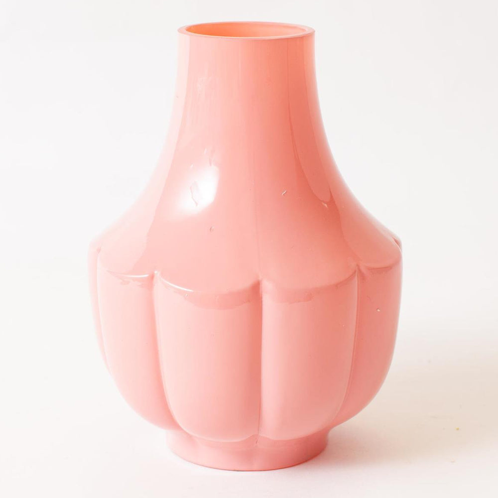 Pink fluted glass vase with a glossy finish and scalloped base, perfect for modern home decor or floral arrangements.