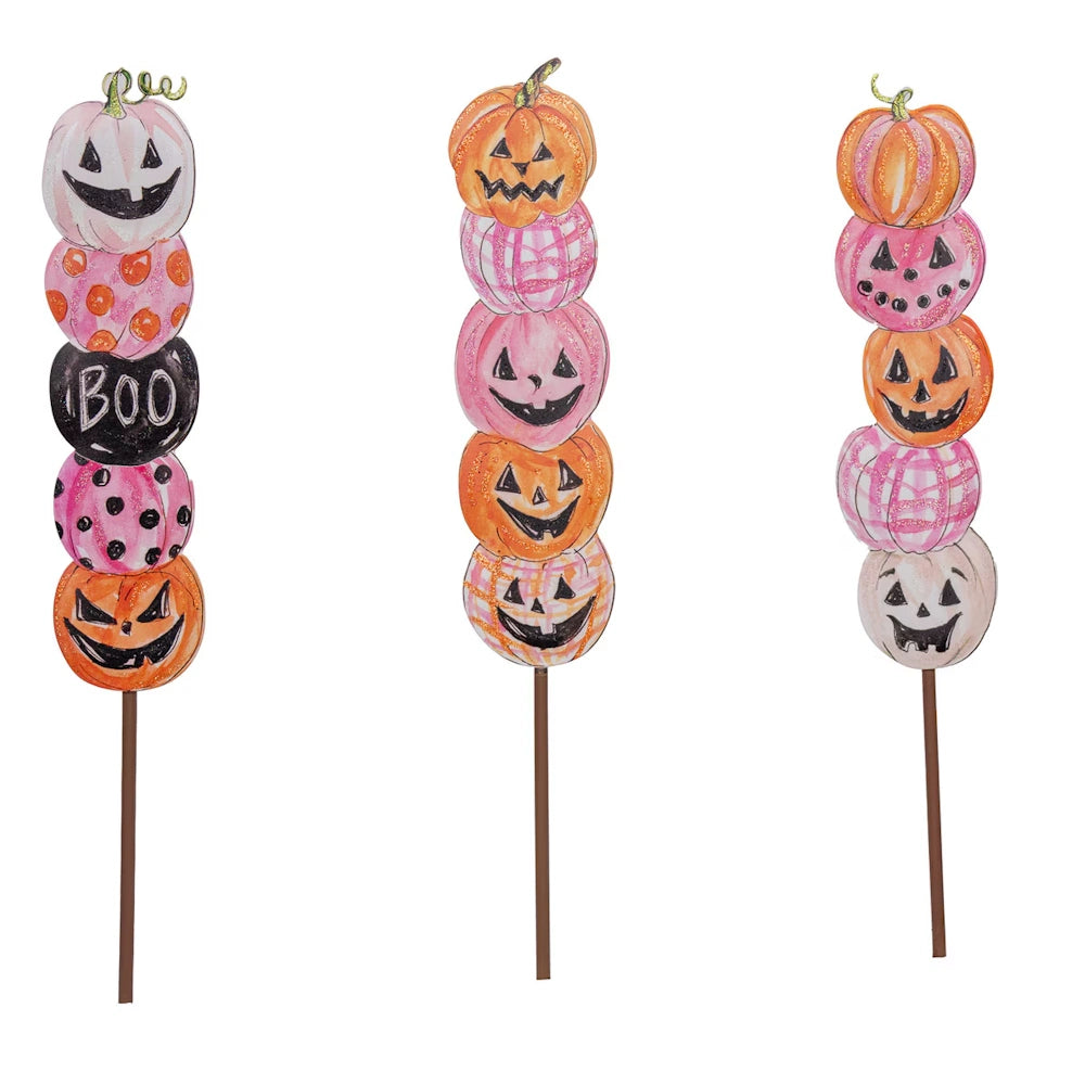 Pink and orange Halloween pumpkin garden stakes with jack-o'-lantern faces and plaid patterns.