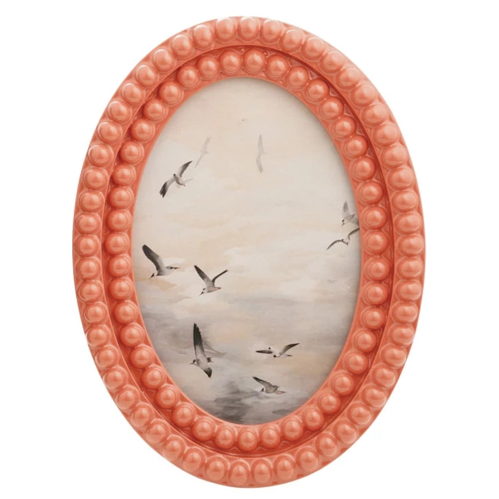 Oval coral bobbin photo frame featuring a painting of seagulls flying against a hazy, clouded sky background.