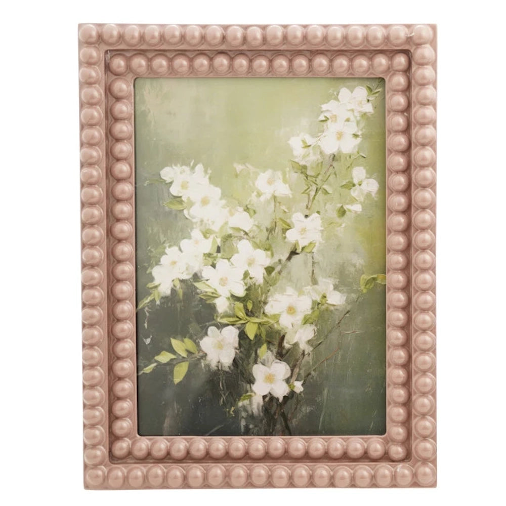 Pink bobbin resin photo frame with white floral artwork and a beaded texture border.