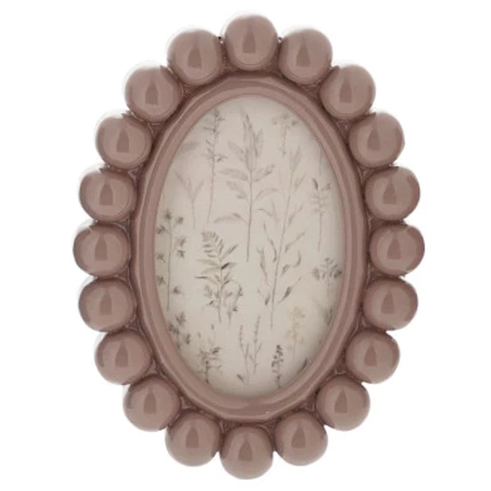 Mauve oval resin bobbin photo frame magnet featuring a delicate botanical illustration of dried wildflowers and ferns.