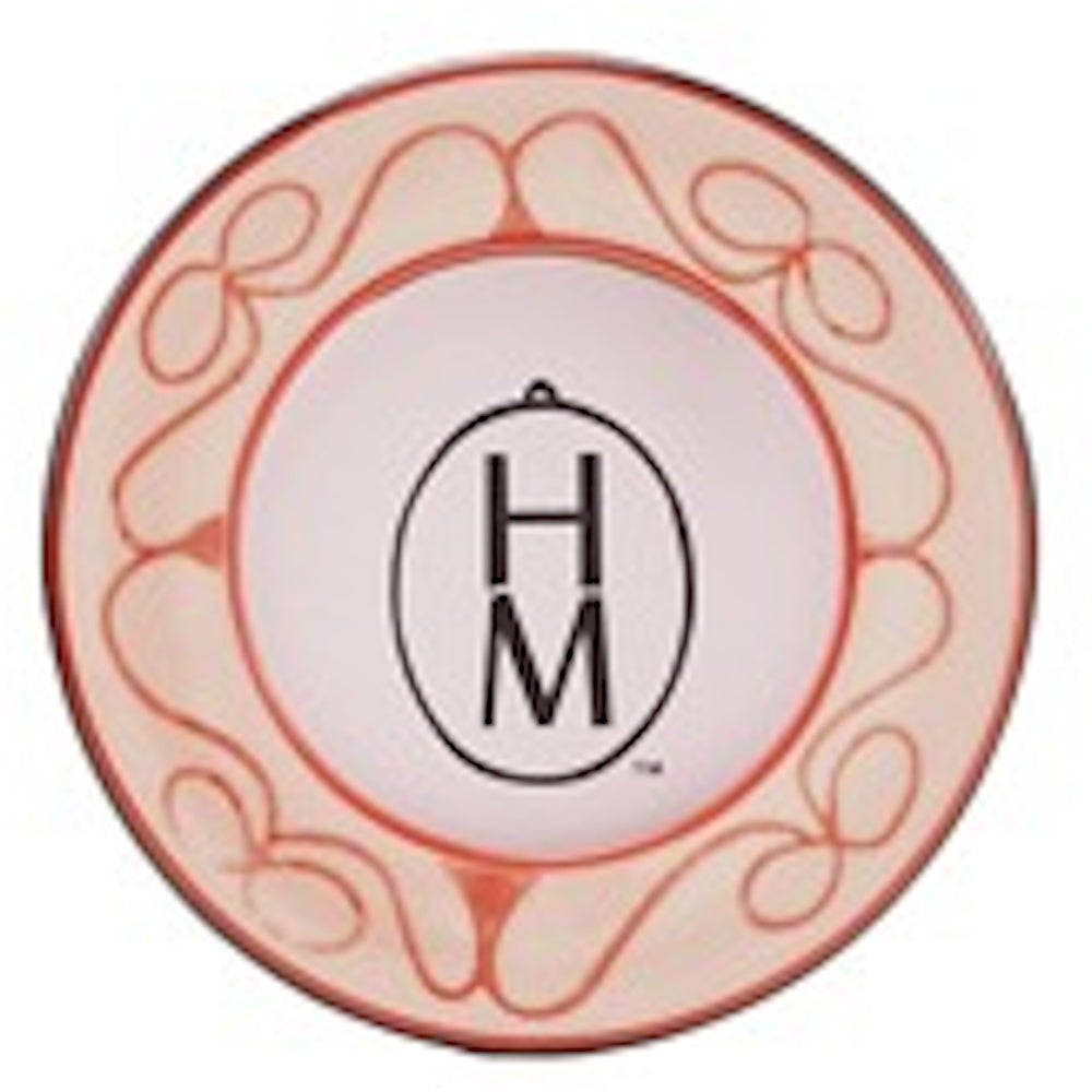 Round pink stoneware magnet with a red decorative scroll border and the letters "HM" inside a black oval at the center.