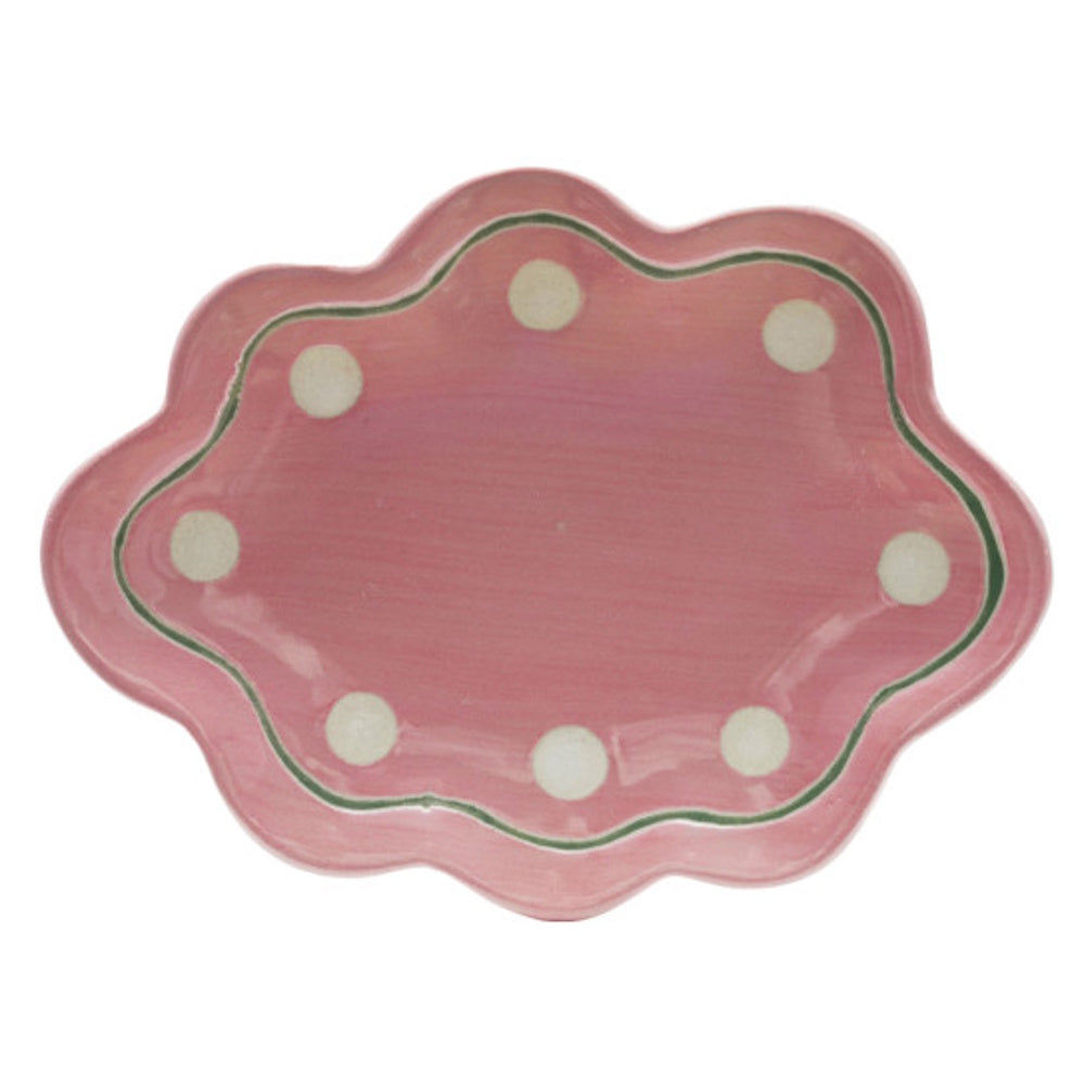 Pink stoneware scalloped dish with white polka dots and a green trim accent.